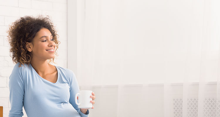 16 week pregnant woman holding cup