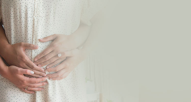 Couple hands holding 15 week pregnant bump