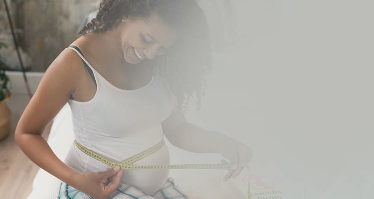 Woman measuring 34 week pregnancy belly